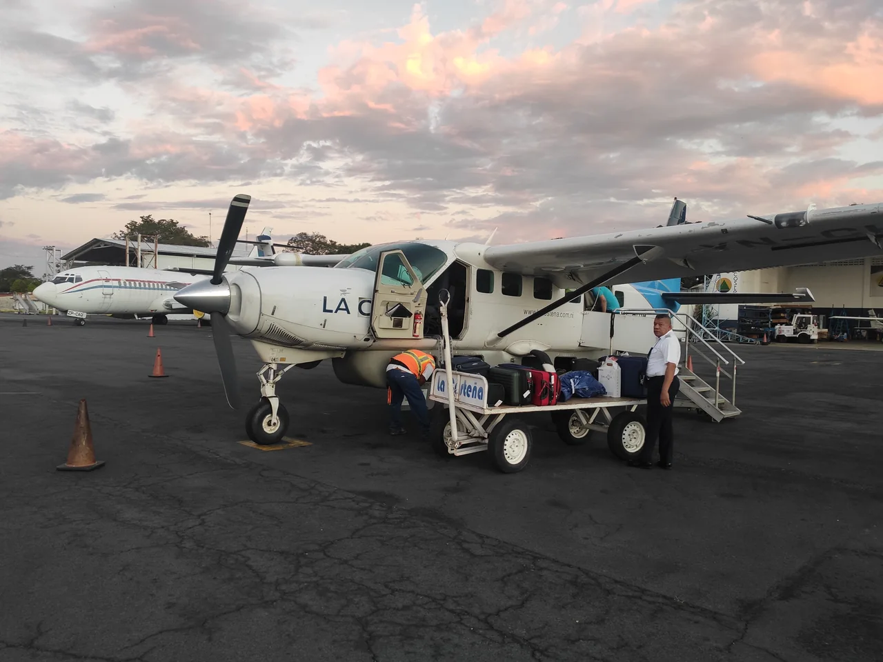 A small propeller aircraft being loaded on the tarmac for the flight to the Corn Islands